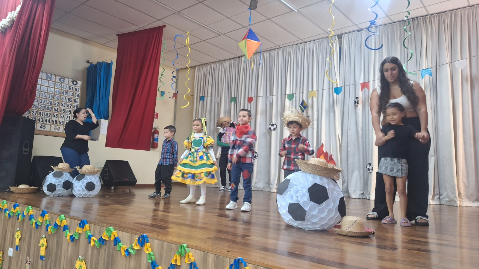Crianças apresentando uma festa junina no palco