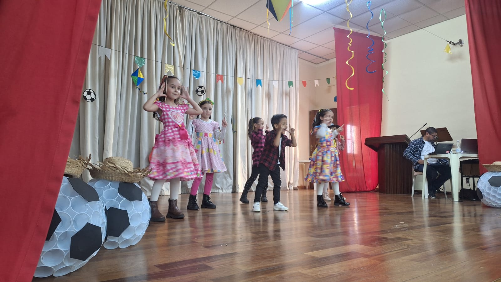 Crianças fantasiadas dançando no palco